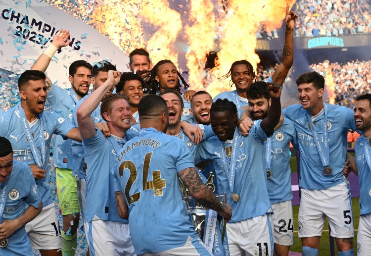 Kyle Walker holds the Premier League trophy while celebrating with teammates
